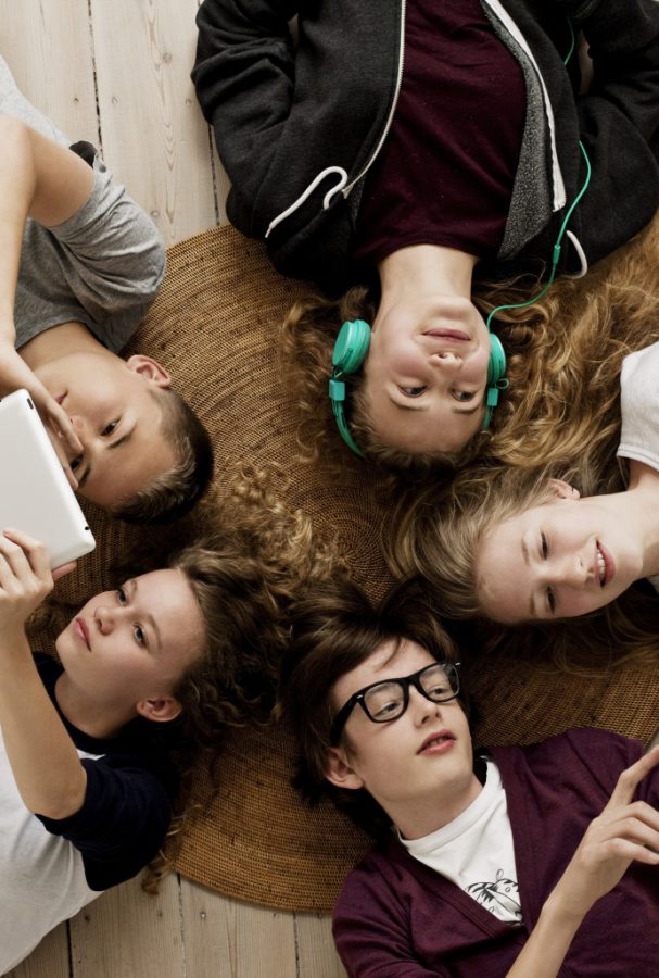 Teenagers lying on floor with Ipad and mobile